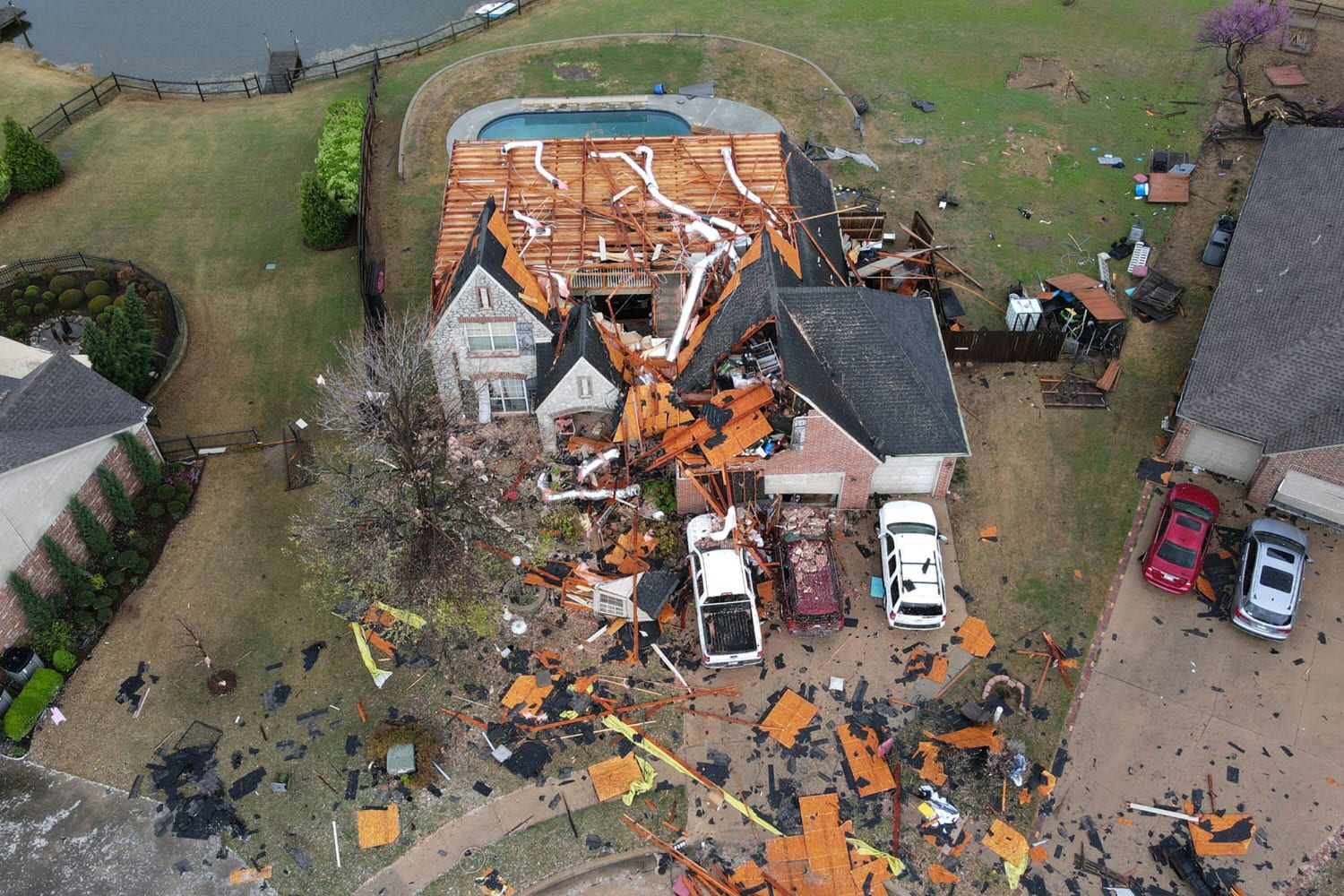 Aerial view shows extensive damage to a residential home destroyed by tornado, with debris scattered across in Oklahoma. The home's roof has been completely in Kent, OH