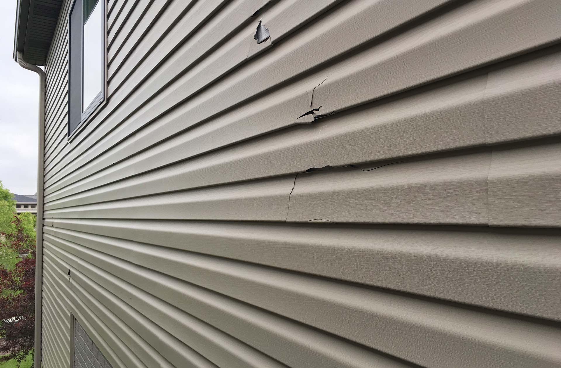 Siding Repair | Storm Damage & Panels | Roof Gutter Now 2 Hail dented and cracked vinyl siding panels
