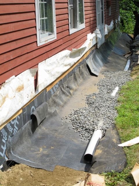 Foundation french drain waterproofing system installation along house exterior