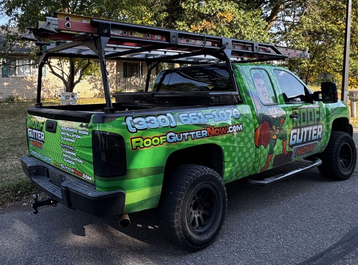 Bright green pickup truck with roof and gutter service branding and equipment rack