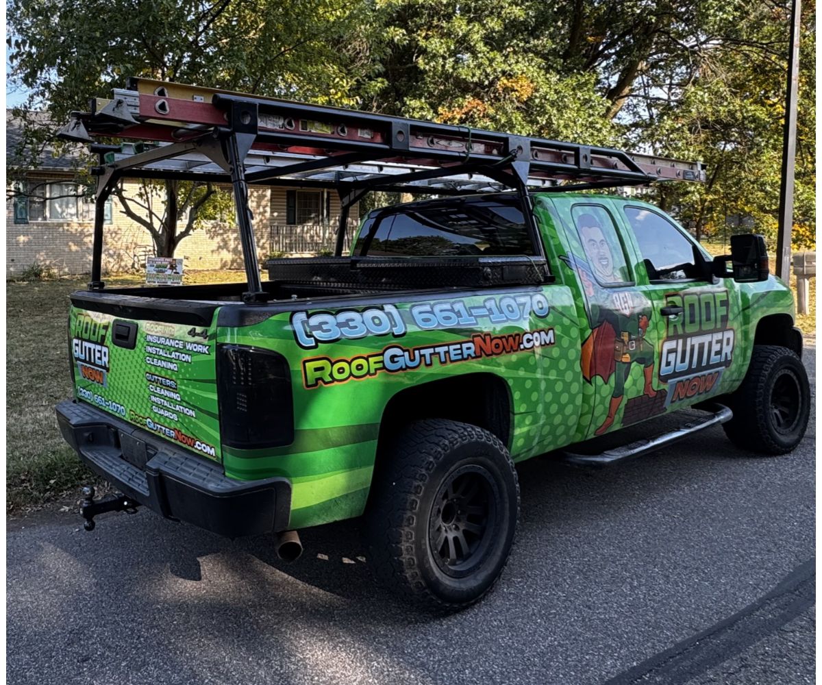 Bright green pickup truck with roof and gutter service branding and equipment rack