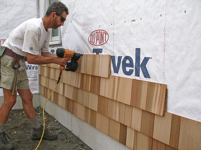 Installer hanging cedar shingle siding
