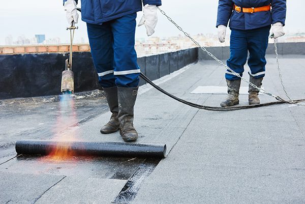 Crew working a commercial low-slope roof system