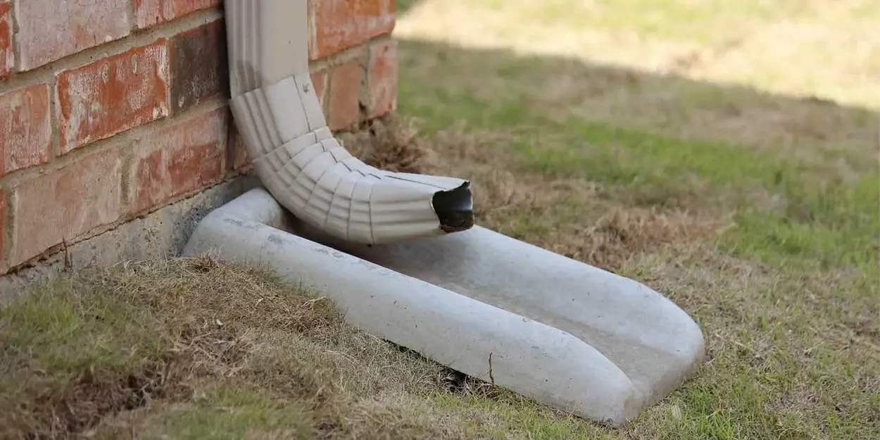 Concrete splash block directing downspout water away