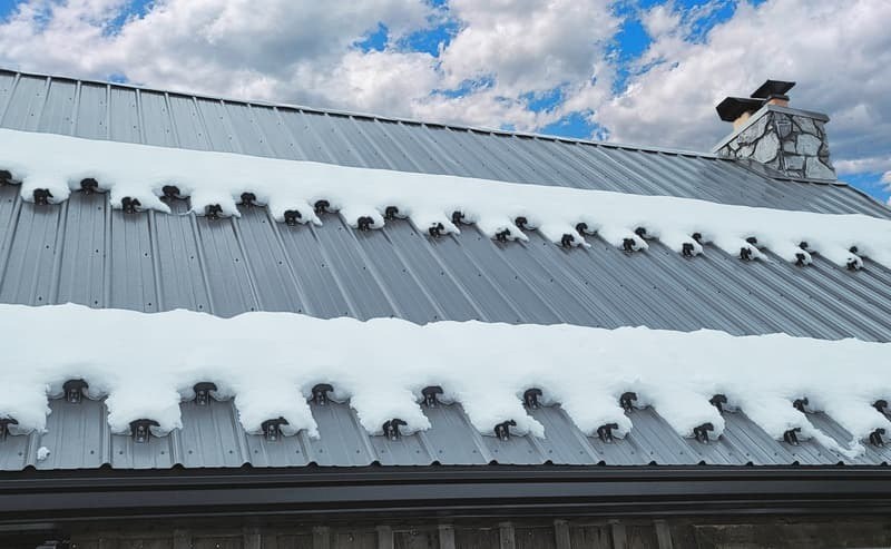 Snow retention blocks holding snow on metal roof