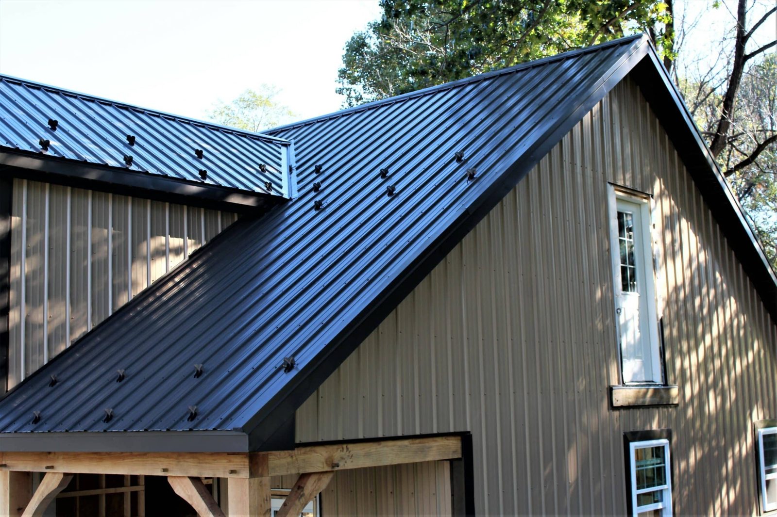 Modern residential home with dark metal standing seam roof and metal siding