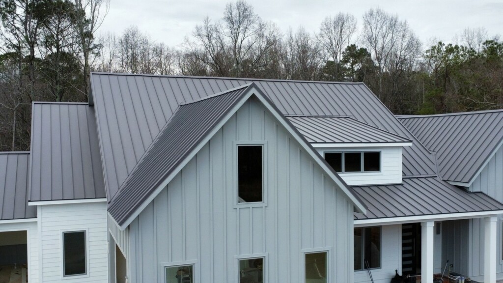 Aerial drone photo showcasing a modern home with standing seam metal roofing and white exterior in North Canton, OH
