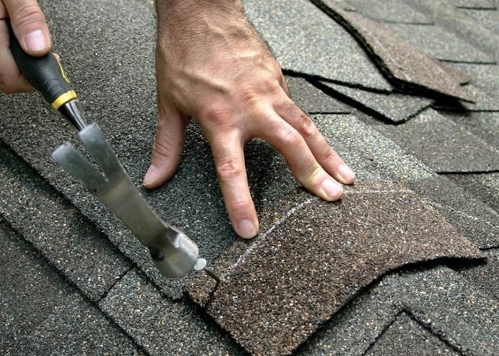 Roof Maintenance Program | Roof Gutter Now OH/PA/NY 1 Roofer checking shingles and sealant during maintenance
