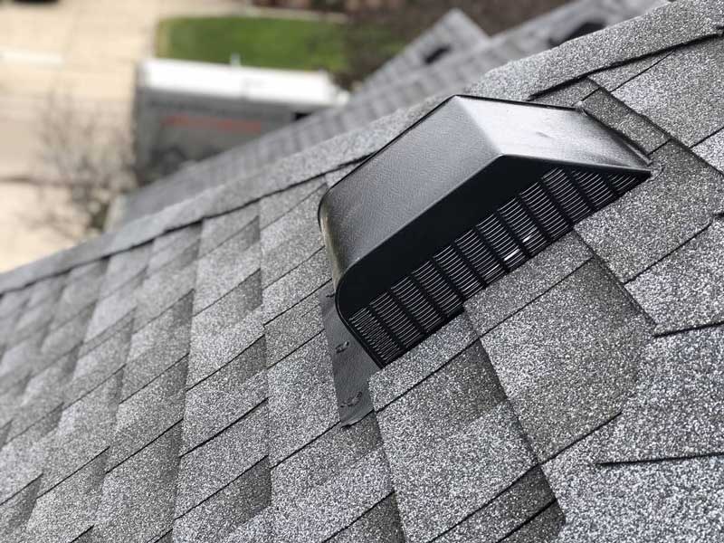 Black roof vent cut and flashed into asphalt shingles