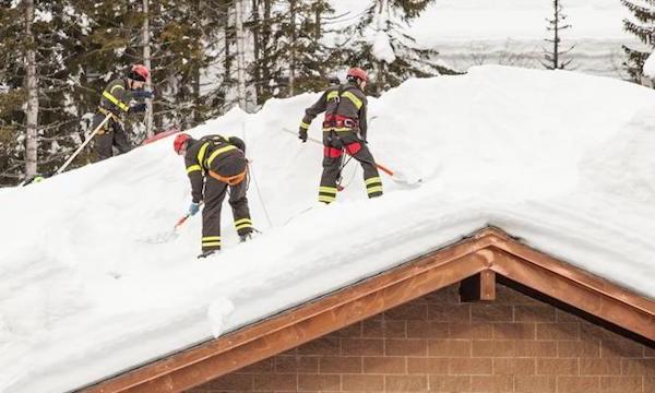 Roof Snow Removal in Medina, OH | Roof Gutter Now 4 Trained crew safely removes heavy snow buildup from residential roof using proper safety equipment in Medina, OH