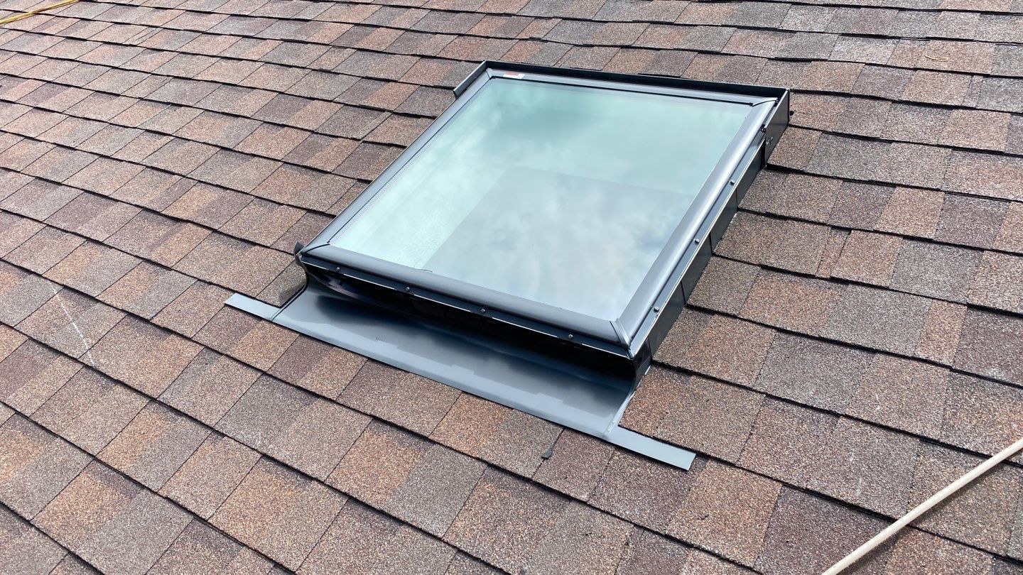 Square skylight installed on residential shingle roof